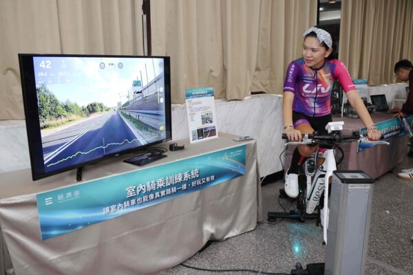 「室內騎乘訓練系統」整合騎乘訓練台與互動軟體，讓教練能即時掌握坡度與體能變化，協助選手精準訓練。圖為國立臺灣體育運動大學自由車專任教練曾可妡示範訓練。